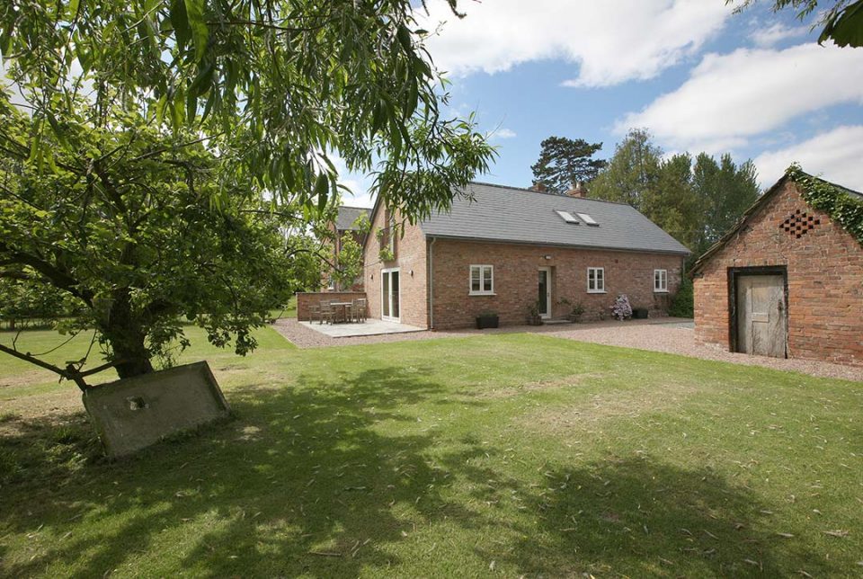 View of cottage and its own terrace from under the apple trees.